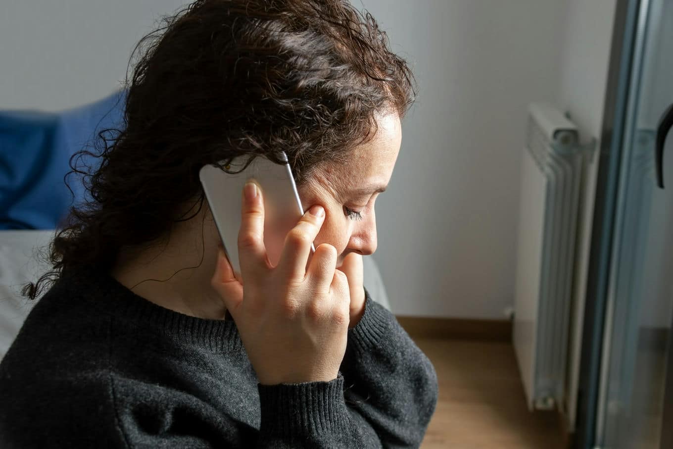 przygnębiona kobieta rozmawiająca przez telefon